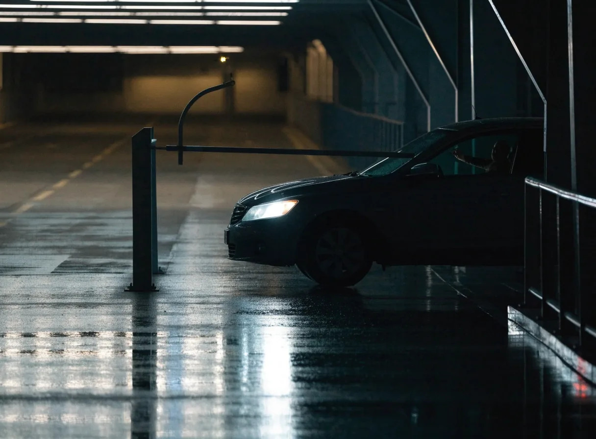 A car arriving at the raised boom gate on Level 1 of the T123 Car Park at night